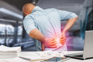 Hombre tentado en una silla con dolor de espalda